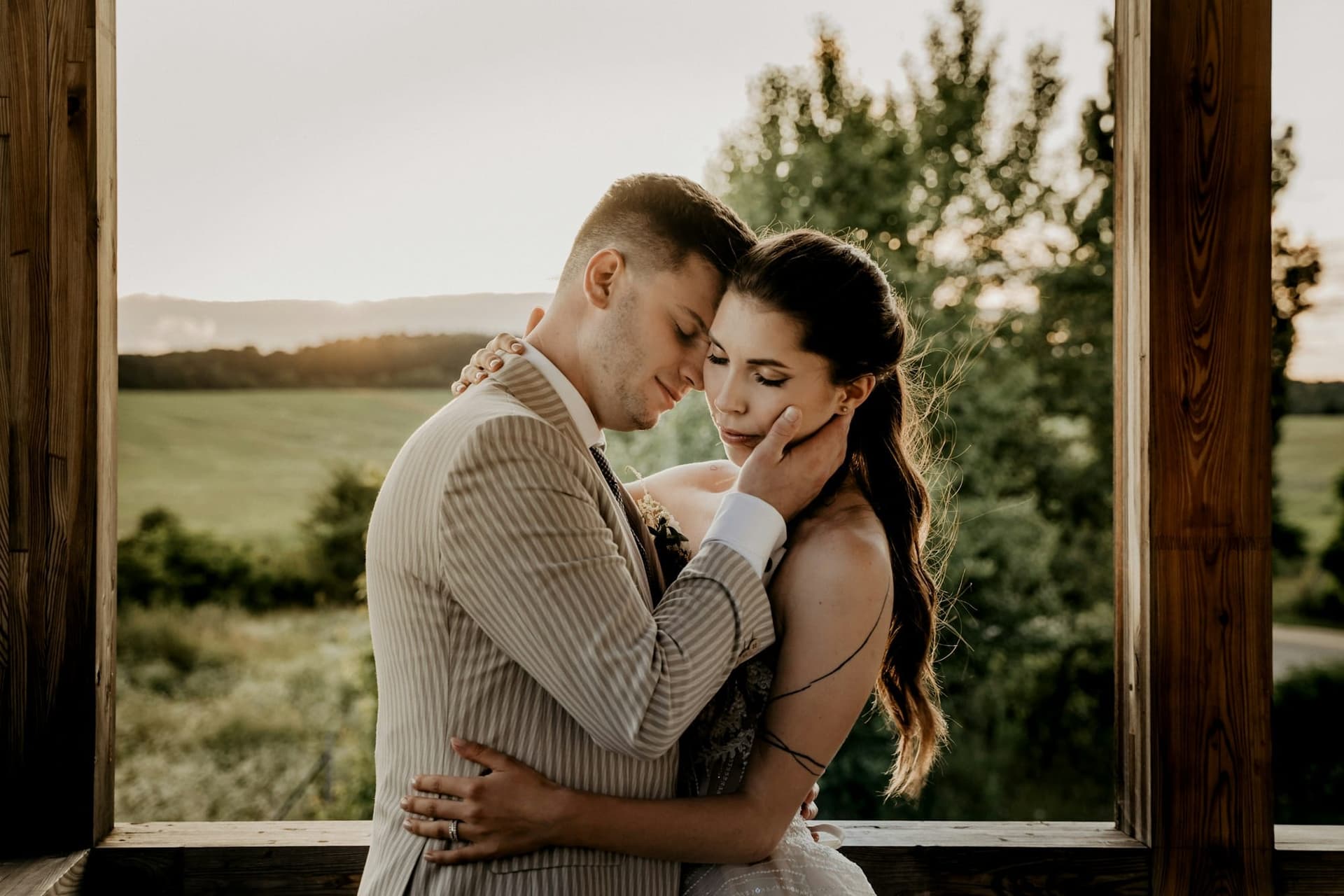 Emma and James embracing in the golden evening light